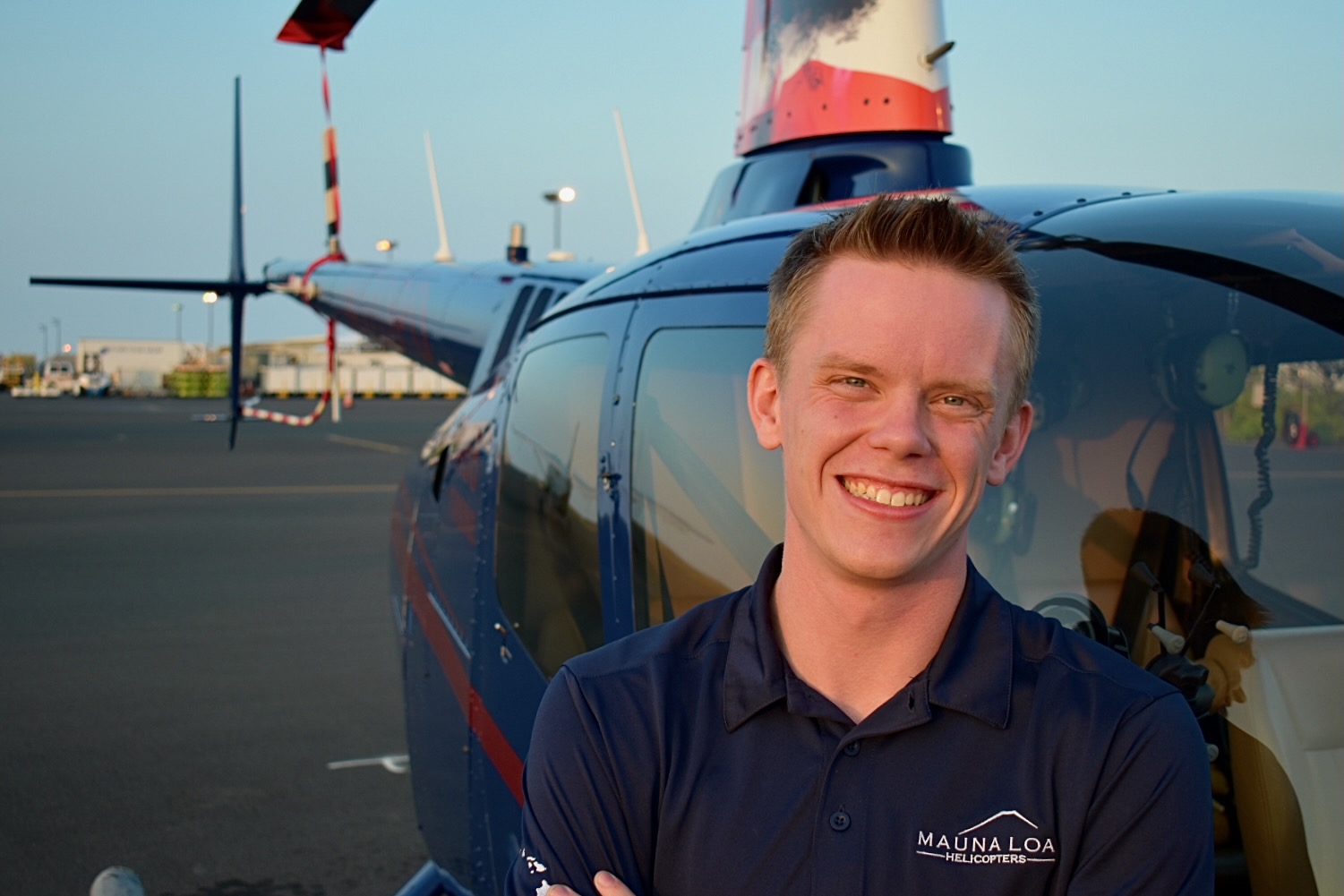 Jack Christensen posing in front of a helicopter.