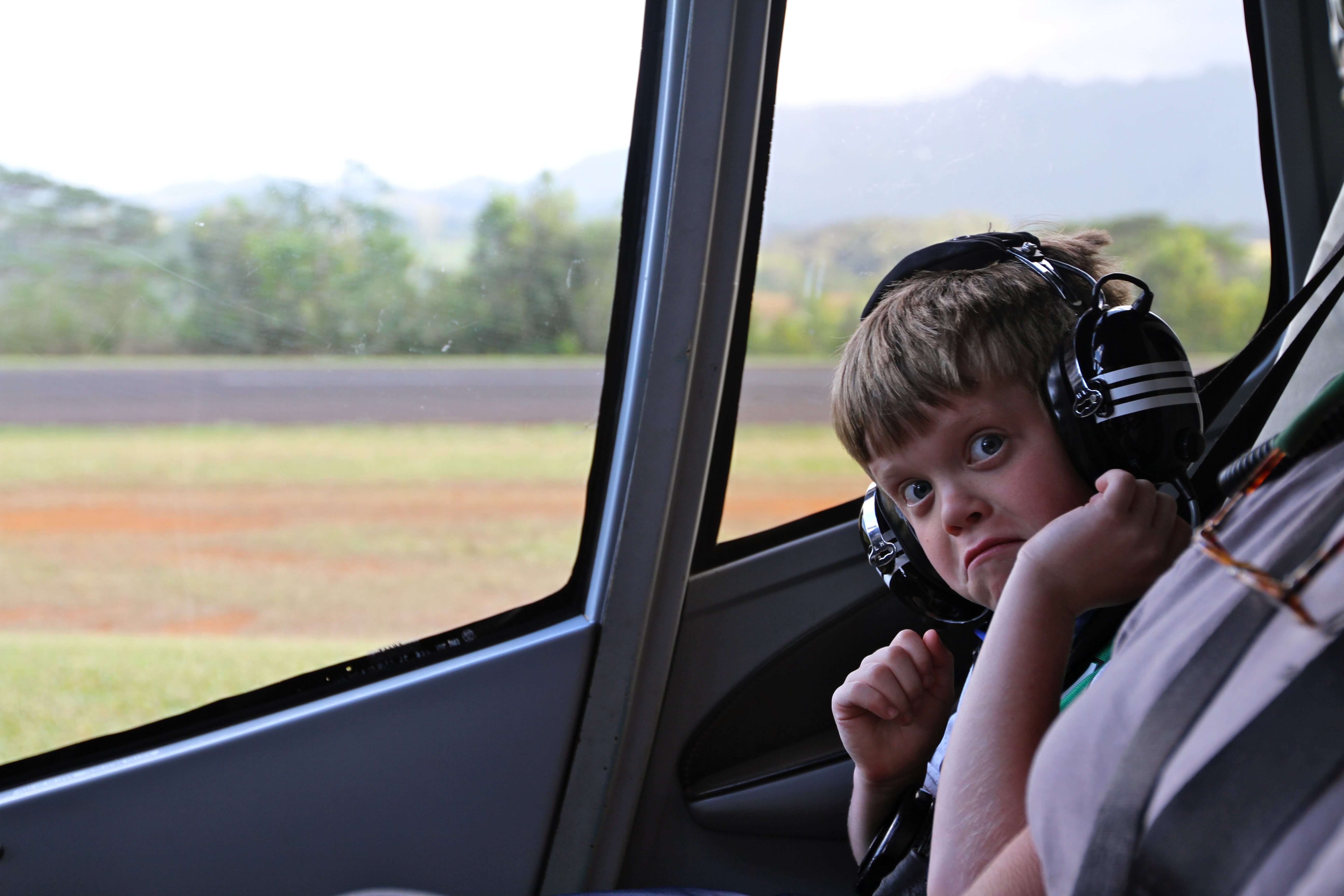 Child with large headphones in a helicopter.
